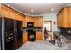 Kitchen with oak cabinets, black appliances, and granite countertops at 219 Society Rd, Statesville, NC 28625