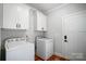 Bright laundry room features white cabinets, washer, and dryer at 301 Tomberlin Rd, Mount Holly, NC 28120