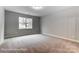 Comfortable bedroom with a large window, soft carpet, and neutral paint at 5108 Verona Rd # 94, Charlotte, NC 28213