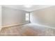 This bedroom features neutral walls, carpet flooring, a window, and is awaiting your personal touch at 5108 Verona Rd # 94, Charlotte, NC 28213