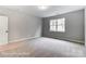 Bright bedroom with a large window, soft carpet, and neutral paint at 5108 Verona Rd # 94, Charlotte, NC 28213