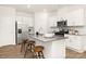 Modern kitchen featuring white cabinets, stainless steel appliances, and a large island with bar stools at 5219 Reedy Ridge Rd, Charlotte, NC 28215