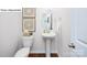 Stylish powder room with pedestal sink and wood flooring at 541 Zermatt Ct, Monroe, NC 28112