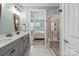 Stylish bathroom with double vanity, frameless shower, and view to the primary bedroom at 6289 Raven Rock Dr, Denver, NC 28037