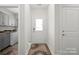 Hallway with exterior door, grey cabinets, and laundry area at 6289 Raven Rock Dr, Denver, NC 28037