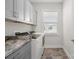Laundry room features grey cabinets with modern washer and dryer at 6289 Raven Rock Dr, Denver, NC 28037