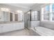 Bright bathroom featuring granite countertop, glass enclosed shower and soaking tub at 704 Kenway Loop, Mooresville, NC 28117