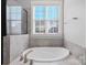 Soaking tub with tile surround and large window provides ample natural light at 704 Kenway Loop, Mooresville, NC 28117
