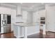 Close up of kitchen with white cabinets, stainless steel appliances, and large island with granite countertop at 704 Kenway Loop, Mooresville, NC 28117