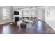 Bright living room with a fireplace, tray ceiling, hardwood floors, and large windows for natural light at 704 Kenway Loop, Mooresville, NC 28117
