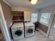 Bright laundry room with a modern washer and dryer, practical shelving, and natural light from multiple windows at 913 9Th Ne Ave, Hickory, NC 28601