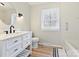 Bright bathroom features a modern vanity with a large round mirror and wood-look floors at 1008 E Sandy Ridge Rd, Monroe, NC 28112