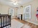 Bright Bedroom with hardwood floors, white trim, a crib, and shelving at 1008 E Sandy Ridge Rd, Monroe, NC 28112