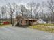 Charming brick house featuring a cozy front porch and gravel driveway at 1008 E Sandy Ridge Rd, Monroe, NC 28112