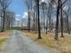 Long gravel driveway leading to a house with mature trees at 1008 E Sandy Ridge Rd, Monroe, NC 28112