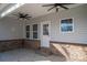 Covered back patio with brick detailing, ceiling fan, and access door at 102 Lake George Dr, Shelby, NC 28152