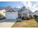 Two-story house with gray siding, white garage door, and landscaping at 102 Lake George Dr, Shelby, NC 28152