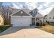 Two-story house with gray siding, white garage door, and landscaping at 102 Lake George Dr, Shelby, NC 28152