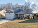 Gray siding two-story house with a white garage door and landscaping at 102 Lake George Dr, Shelby, NC 28152