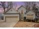 Charming two-story house with a beige exterior, landscaped yard, and nighttime lighting at 110 Creekside Dr, Fort Mill, SC 29715