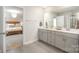 Modern bathroom with double vanity and a view into the bedroom at 12613 Stoneybrook Station Pkwy, Huntersville, NC 28078