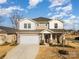 Two-story house with gray siding, stone accents, and a three-car garage at 12613 Stoneybrook Station Pkwy, Huntersville, NC 28078