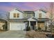 Two-story house with gray siding, stone accents, and a three-car garage at 12613 Stoneybrook Station Pkwy, Huntersville, NC 28078