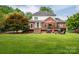 View of the home from the backyard, showcasing a large deck, mature trees, and well-maintained lawn at 133 Castaway Trl, Mooresville, NC 28117