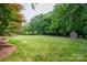 Lush, expansive backyard with mature trees, a garden shed, and ample green space for outdoor activities at 133 Castaway Trl, Mooresville, NC 28117