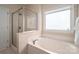 Bright bathroom features a soaking tub, separate glass shower and a frosted window at 133 Castaway Trl, Mooresville, NC 28117