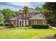 Imposing two-story brick home features a meticulously manicured front yard and mature landscaping at 133 Castaway Trl, Mooresville, NC 28117