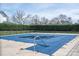 Community pool covered for the off-season, fenced and surrounded by mature trees and other neighborhood buildings at 133 Castaway Trl, Mooresville, NC 28117