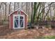 Shed with white trim in a backyard setting, surrounded by mulch and trees at 133 Castaway Trl, Mooresville, NC 28117