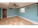 Basement room with light teal walls and wood flooring at 218 Kingsway Cir, Charlotte, NC 28214