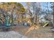 Large backyard with patio, playset, and mature trees at 2512 Heathershire Ln, Matthews, NC 28105