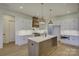 Bright kitchen boasts a large island, white cabinetry, and stylish light fixtures at 2712 Yellow Bell Way, Monroe, NC 28112