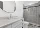 Modern bathroom with gray tile, a walk-in shower, and a large vanity at 308 Dover Ave, Charlotte, NC 28209