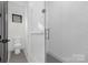 Small bathroom with toilet and shower, gray tile floor at 308 Dover Ave, Charlotte, NC 28209