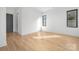 Well-lit bedroom featuring hardwood floors and a gray door at 308 Dover Ave, Charlotte, NC 28209