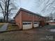 Rear view of brick house with double garage and side yard at 3103 Minnesota Rd, Charlotte, NC 28208