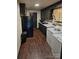 Galley kitchen with dark cabinets and appliances at 3103 Minnesota Rd, Charlotte, NC 28208