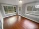 Bright sunroom with wood floors, access to deck, and view of backyard at 4616 Whispering Oaks Dr, Charlotte, NC 28213