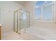 Bathroom with a shower, bathtub, and large window at 4907 Foxbriar Trl, Charlotte, NC 28269