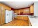 Kitchen with wood cabinets, white appliances, and red accent wall at 4907 Foxbriar Trl, Charlotte, NC 28269