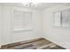 Well-lit bedroom with two windows, window blinds, and wood-look vinyl flooring at 503 Birch St, Lowell, NC 28098