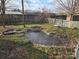 Landscaped backyard with pond, wooden fence, and a swing at 535 Springs East Rd, Lincolnton, NC 28092