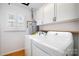 Well-lit laundry room with washer, dryer, and storage cabinets at 670 Sylvan Sw St, Concord, NC 28025