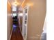 Long hallway with light brown hardwood floors and access to rooms at 6710 Elm Forest Dr, Charlotte, NC 28212