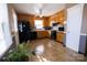 Kitchen with wood cabinets, black appliances, and tile flooring at 6710 Elm Forest Dr, Charlotte, NC 28212