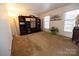 Spacious living room with large windows, brown carpet, and entertainment center at 6710 Elm Forest Dr, Charlotte, NC 28212